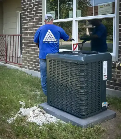 A technician from Tri-Tech Mechanical Group works on maintaining a customer's AC unit.